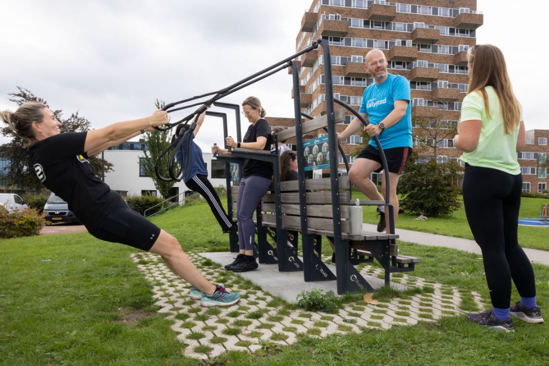 De deelnemers van de sportles samen met wethouder Bakelaar (in het blauw rechts) in actie.