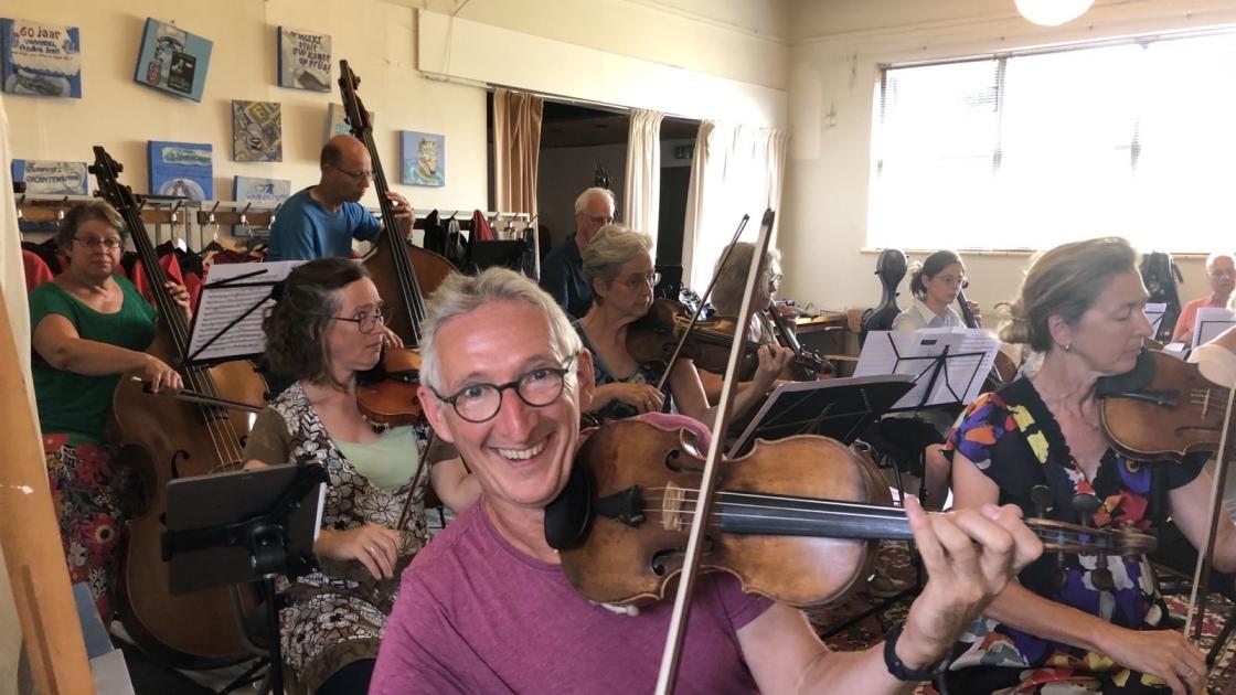 Concertmeester Martijn zorgt dat iedereen zijn strijkstok de goede kant op heeft 